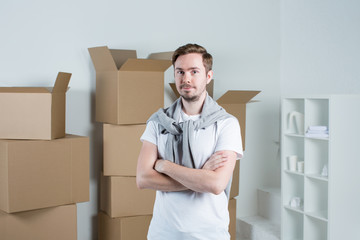 Handsome Man with moving boxes in new modern apartment.