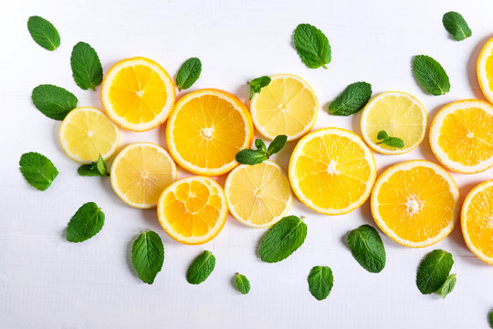 White background with lemon, orange slices and mint. Concept with fresh fruit. Lemon, Orange, Mint. View from above.