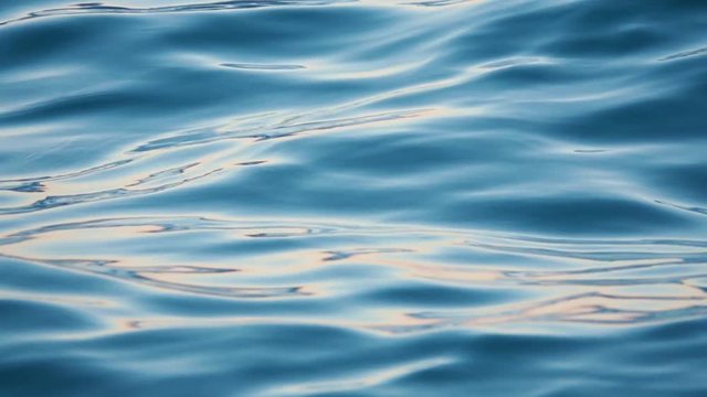 Close up of disturbed blue ocean water surface. Slow motion