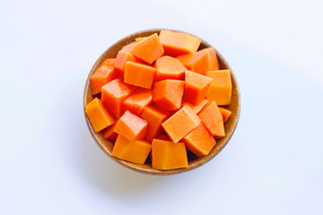 Papaya in wooden bowl on white