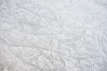 Floor background of a frozen ice rink with skate marks, with white snow during the winter.