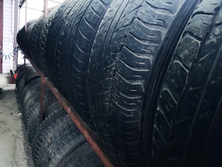 row of worn tires on a rack in the garage
