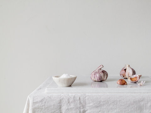 Pink garlic and sea salt flakes on white marble