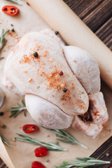 Raw chicken, pepper and fresh herbs on wooden table ready for cooking 