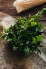 Bunch of fresh green parsley twigs on wooden background