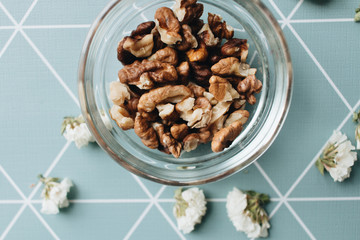 Pile of shelled walnuts in glass bowl, healthy eating concept