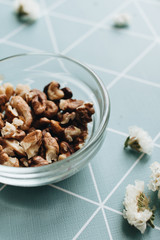 Pile of shelled walnuts in glass bowl, healthy eating concept