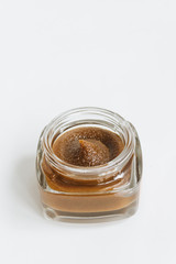 Chocolate cream in small jar on white background