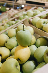 Pile of fresh ripe green apples in boxes at market