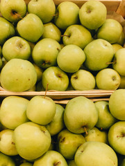 Pile of fresh ripe green apples in boxes at market