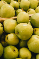 Pile of fresh ripe green apples in boxes at market
