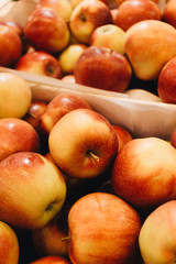 Pile of fresh ripe red apples in boxes at market
