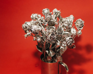 Christmas decoration with silver roses on red background