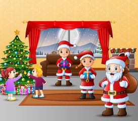 Obraz na płótnie Canvas Happy three santa claus with kids decorating christmas tree