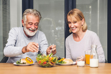 Senior couple enjoy eating  healthy breakfast together in the kitchen.Retirement couple concept