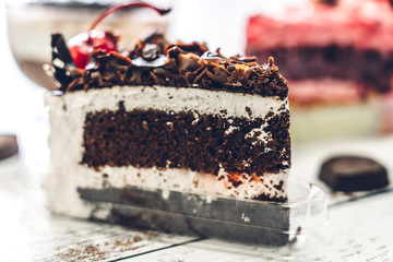 Delicious chocolate cake slice on white wooden table