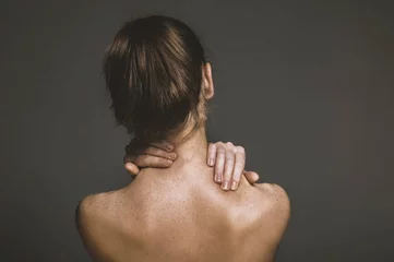 Fotobehang Woman suffering for chronic neck pain. © Piotr Marcinski