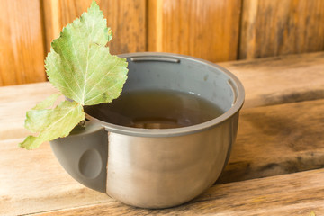 Hot tea in a mug from a thermos with a birch leaf in a bath