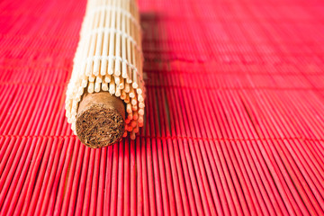 Brown cigar wrapped in oriental bamboo mat.