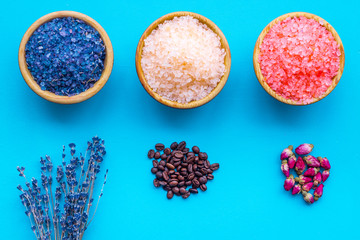 Aromas of bath salt. Coffee, rose, lavender near bowls with colorful bath salt on blue background top view