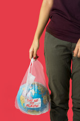 Unknown woman carrying a globe in a plastic bag