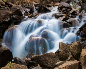 Mountain stream cascade falls over rocks