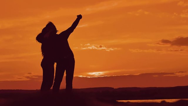 Couple silhouette doing selfie outdoors. Man and girl of best friends taking selfie during sunset. Modern concept of friendship with new trends and technology. Romantic lifestyle silhouette couple