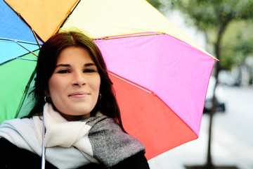 Beautiful woman under rainbow umbrella