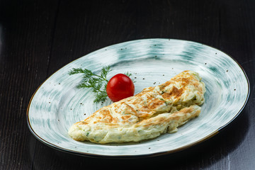 Homemade scrambled eggs with mushrooms with salad on a plate over a dark background. The concept of healthy eating. Flat layout, top view