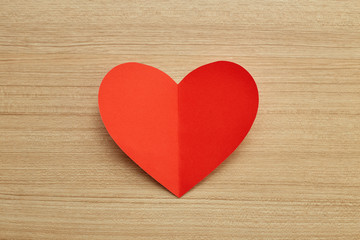 Fototapeta na wymiar Valentine's day red paper heart on wooden