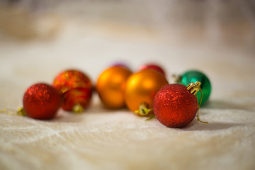 Close-up of Christmas toy lying on soft beige blanket on background blurred Christmas toys