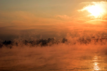 Beautiful sunset over the sea. The mist over the river. Low air temperature.