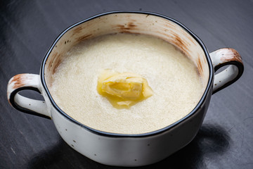Semolina porridge in a vintage Breakfast bowl on a dark wooden table.
