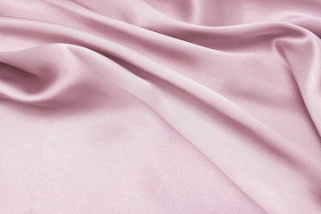 The texture of the satin fabric of pink color for the background