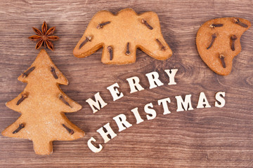 Fresh baked gingerbreads and inscription Merry Christmas as festive decoration