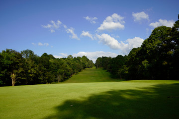 The evening golf course has sunlight shining down at golf course in Thailand