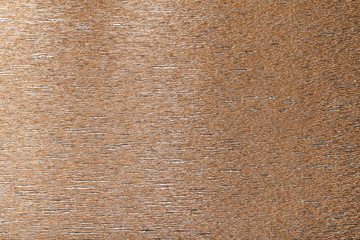 Textural of bronze background of wavy corrugated paper, closeup.