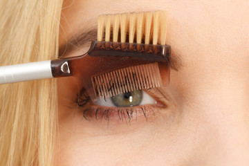 Obraz premium Woman brushing her eyelashes