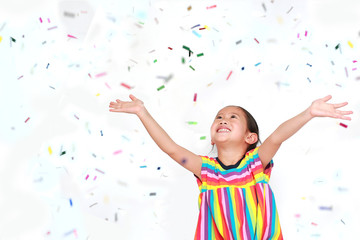 Happy little child girl with colorful confetti on white background. Happy New Year or...