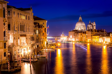Fototapeta premium Bazylika Santa Maria della Salute, Punta della Dogona i Canal Grande o zachodzie słońca w Blue Hour w Wenecji, Włochy z odbiciami