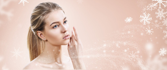 Young woman over beige background with snowflakes.