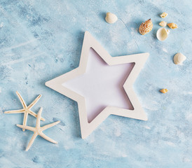 Flat lay top view Summer vacation mockup: star shaped photo frame, seashells and white starfish on...