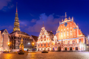 Fototapeta na wymiar Panorama of Riga Old Town Hall Square, Roland Statue, The Blackheads House and St Peters Cathedral illuminated in the twilight, Riga, Latvia