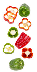 Falling sliced and whole sweet pepper isolated on white background
