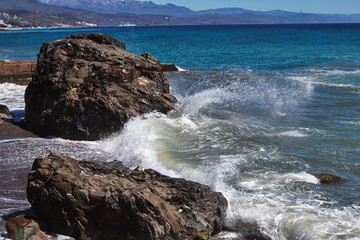 Storm on the coastal zone in sumer's day. Big waves of the Black Sea beat against the rocks.