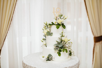  White wedding cake with flowers.  The word Love with heart.