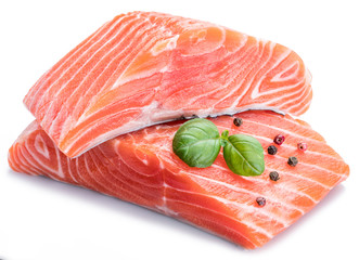 Fresh raw salmon fillets decorated with fresh basil.