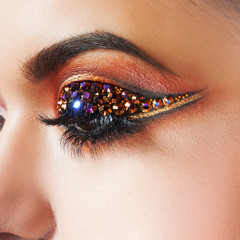 Amazing Bright eye makeup with a arrow with rhinestones. Brown and gold tones, colored eyeshadow