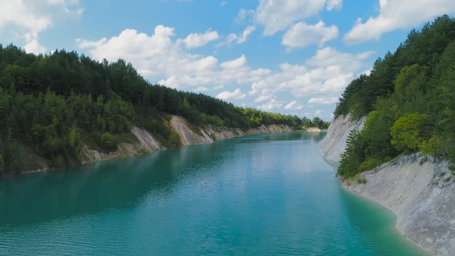 An abandoned plaster pit filled with blue water.