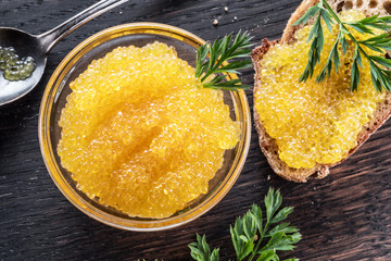 Pike caviar or roe in the bowl on wooden background.